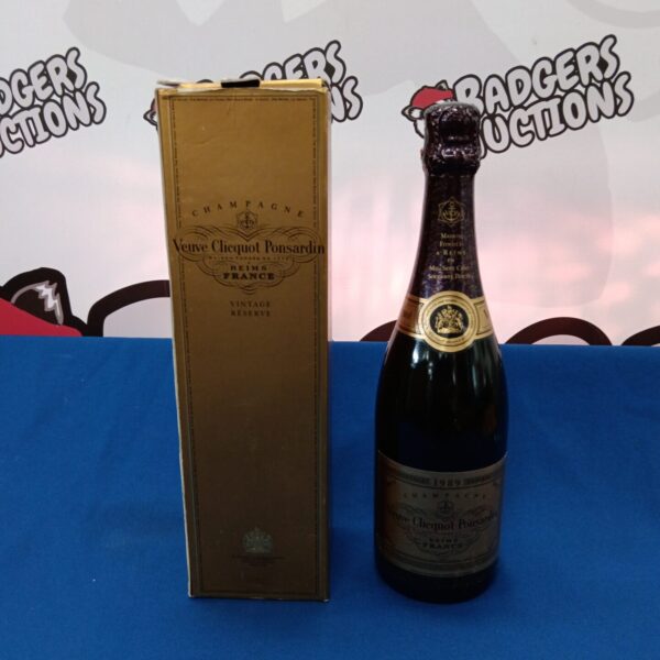 Sealed bottle of vintage Veuve Clicquot champagne with yellow label.