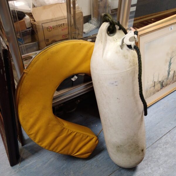 White boat bumper buoy and yellow life ring set for marine safety.