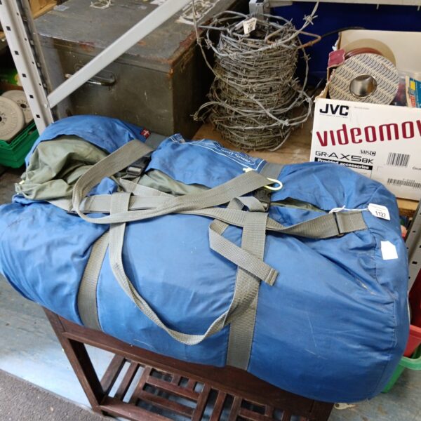 Blue Outwell family tent rolled up for storage.