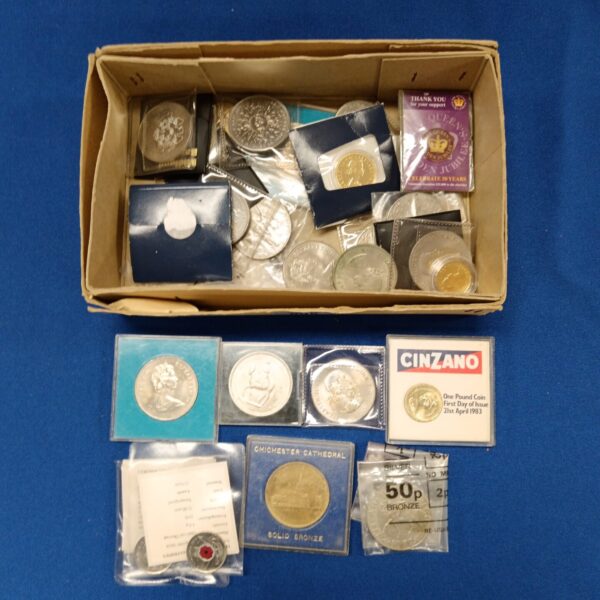 Collection of British commemorative coins in original packaging.