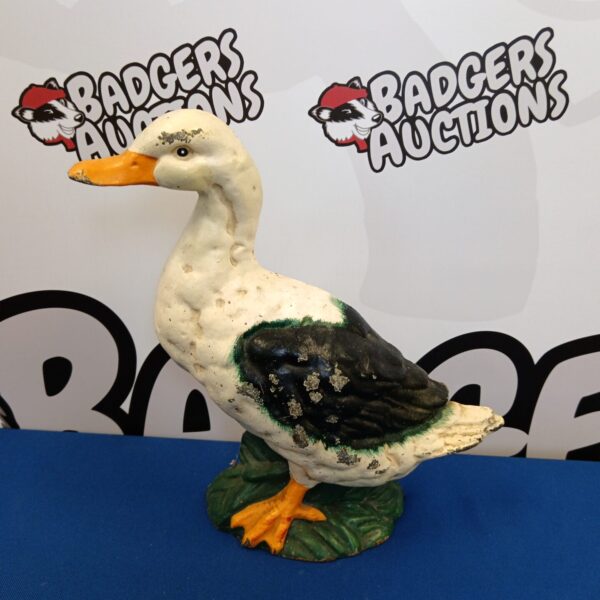 Antique cast iron duck doorstop with orange feet and beak.