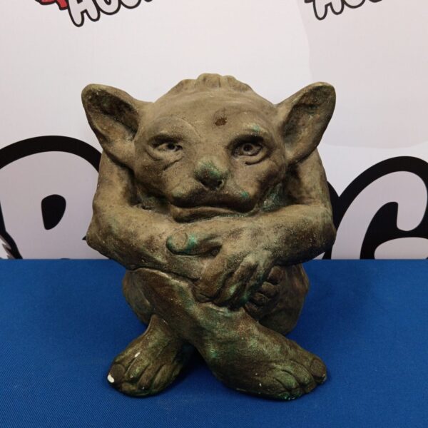 Weathered cast stone gargoyle ornament for garden or gothic decor.