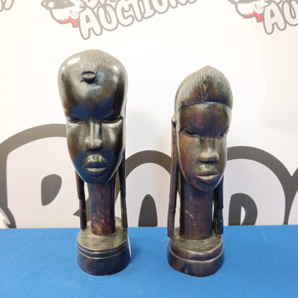 Pair of carved African hardwood busts on display.