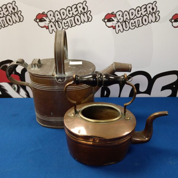 Antique copper kettle and watering can set for garden or farmhouse decor.