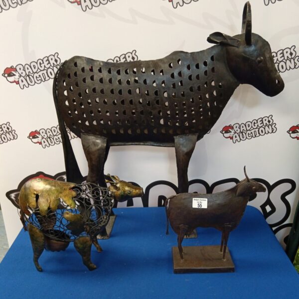 Group of three metal cow sculptures with cut-out designs.