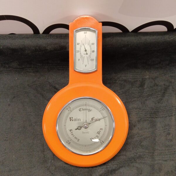Vintage Smiths barometer thermometer in orange, a classic weather instrument.