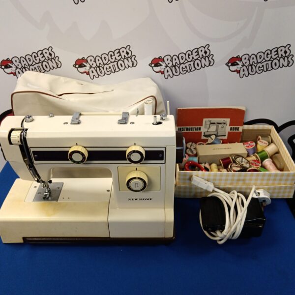 Vintage New Home model 657a sewing machine with attachments.