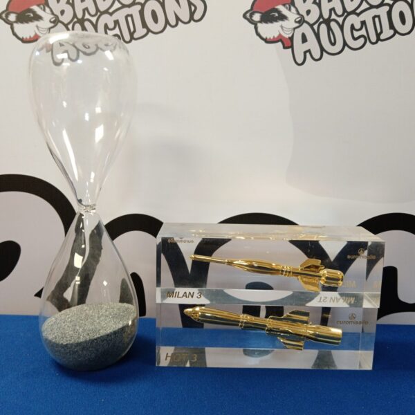 Euro missile Milan 3 and Hot 3 paperweights with hourglass on display.