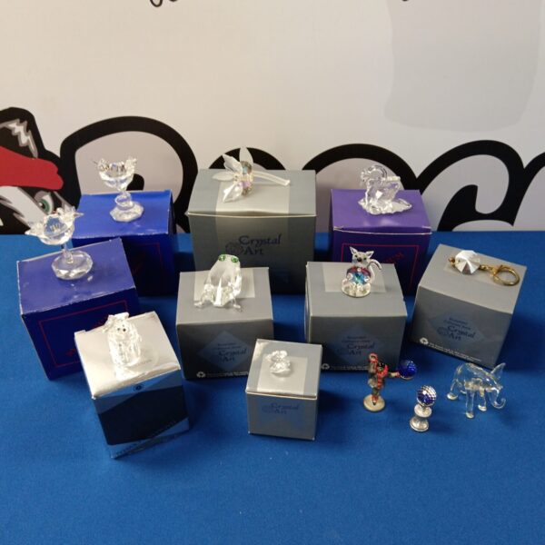Collection of crystal ornaments in original boxes, decorative figurines.
