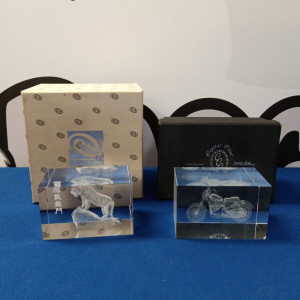 Boxed crystal paperweights featuring a motorcycle and tiger sculpture.