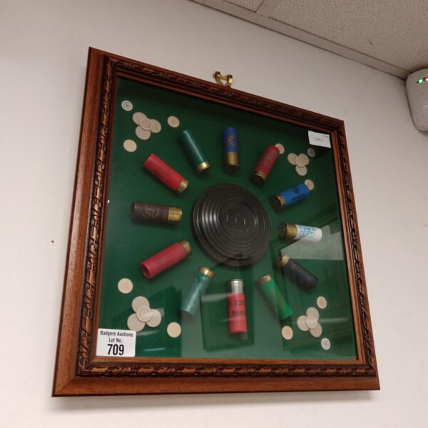 Framed clay pigeon shooting diorama with spent shells.