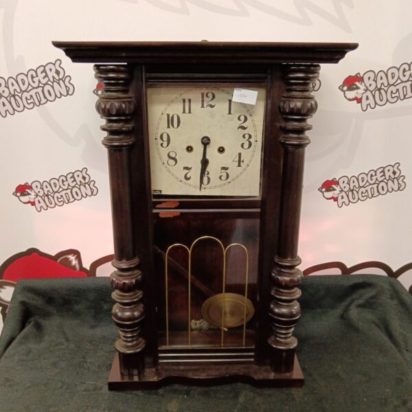 Antique 1906 wall clock with pendulum and Roman numerals.