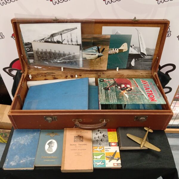 Vintage leather case filled with military books and aviation ephemera.