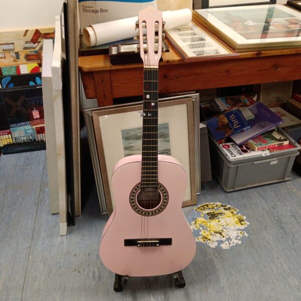 Pink Herald HL34 acoustic guitar in a vintage setting.