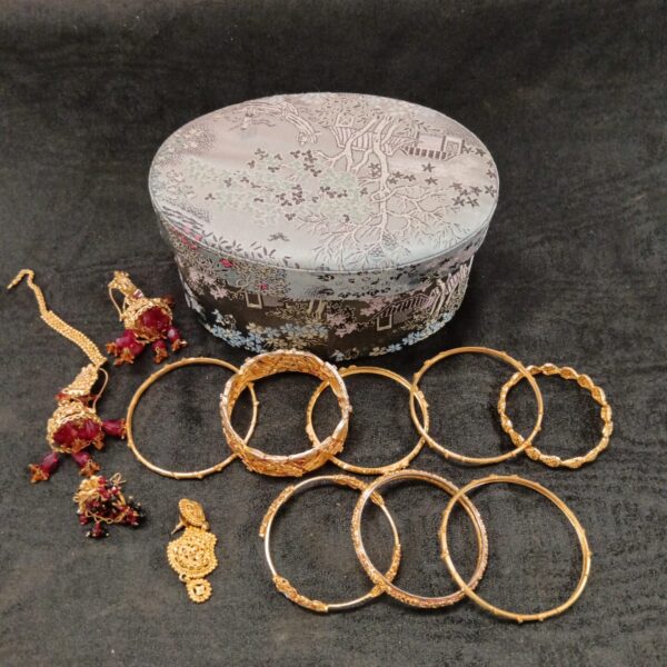 Set of traditional Indian gold plated bangles, showcasing intricate designs.