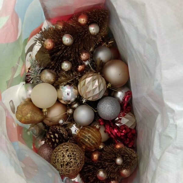 Mixed lot of colourful Christmas baubles and festive decorations.