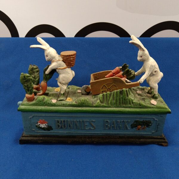 Vintage cast iron bunny bank with wheelbarrow, collectible animal figurine.