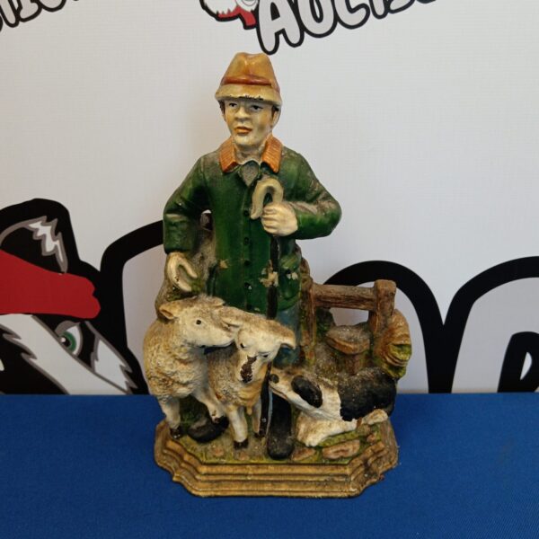 Antique cast iron shepherd doorstop with sheep, a charming collectible.