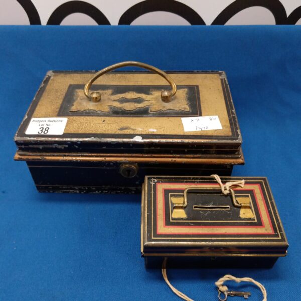Front view of a vintage tin cash box with key.