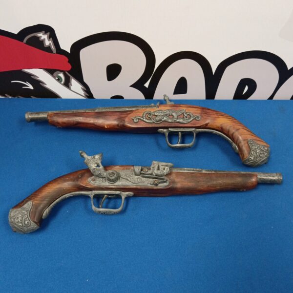 Antique flintlock pistols displayed as a decorative pair.