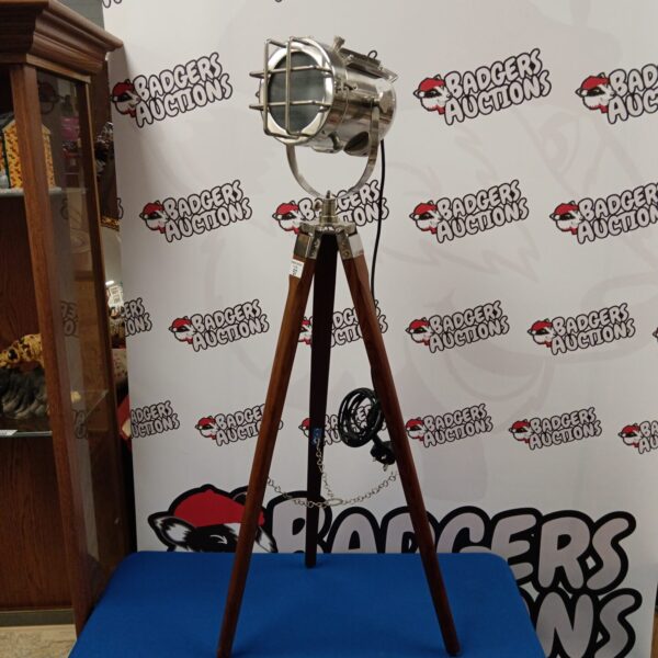 Vintage tripod spotlight lamp with wooden legs and metal reflector.