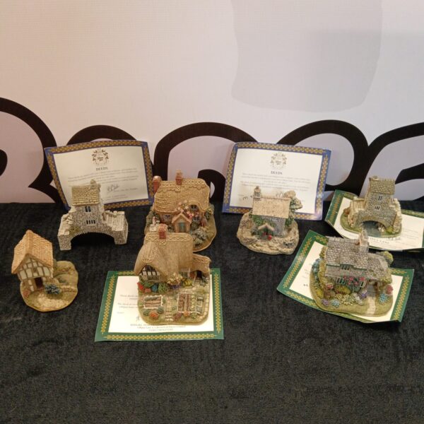 Group of Lilliput Lane cottages with deed certificates displayed.