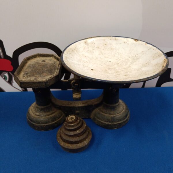 Vintage cast iron scales with enamel pan and weights displayed.