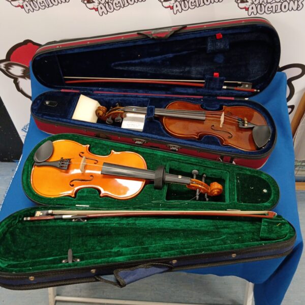 Two violins in a case with a bow, musical instruments.