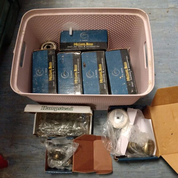 Box of new Heritage Brass door knobs for antique style doors.