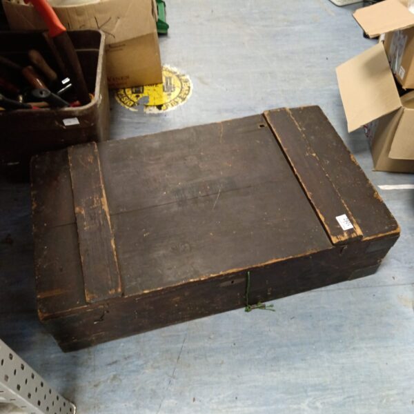 Front view of a vintage wooden lockable trunk.