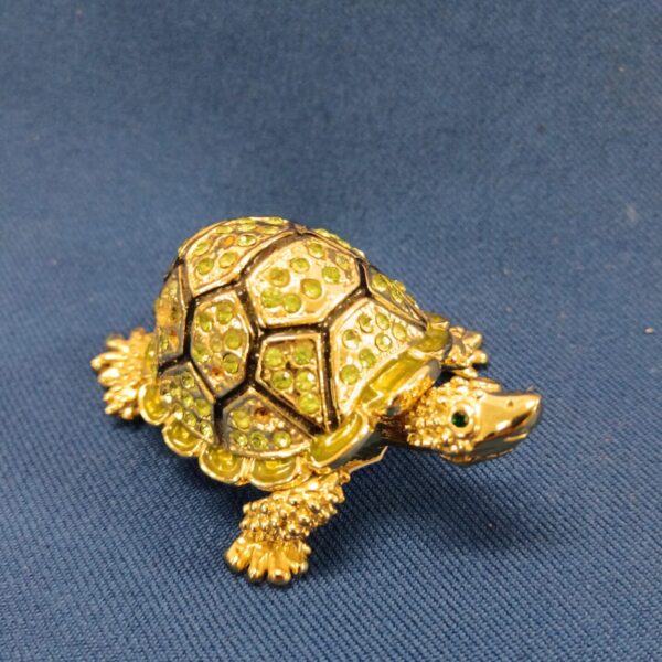 Vintage stone set tortoise trinket pot with green stones.