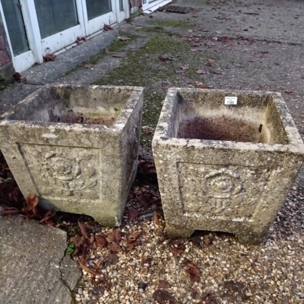 Pair of weathered concrete planters for garden or patio use.