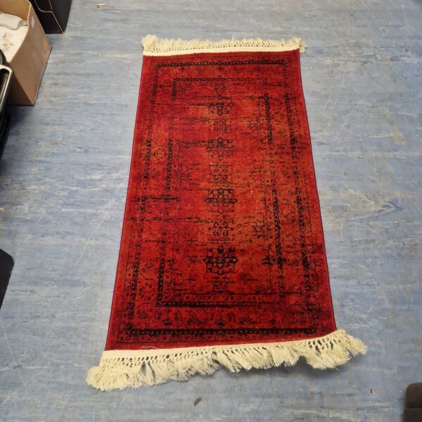 Vintage red area rug with traditional patterned design.