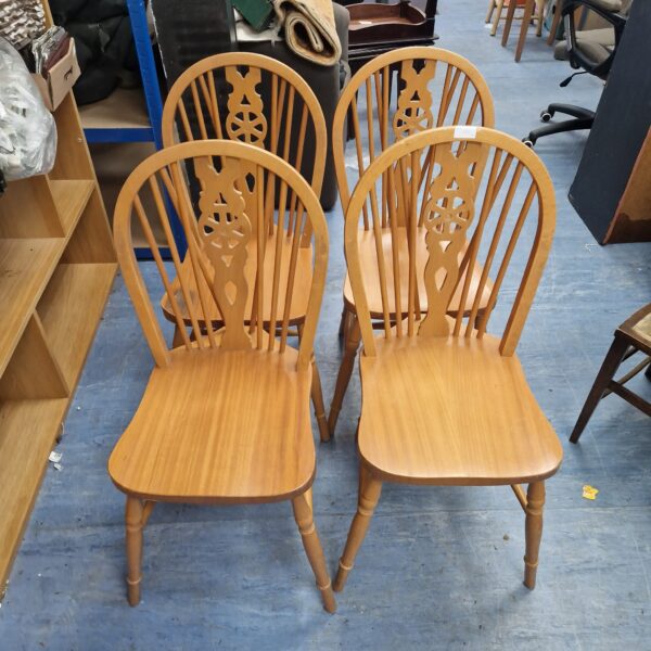 Four vintage wheelback chairs with wooden construction.