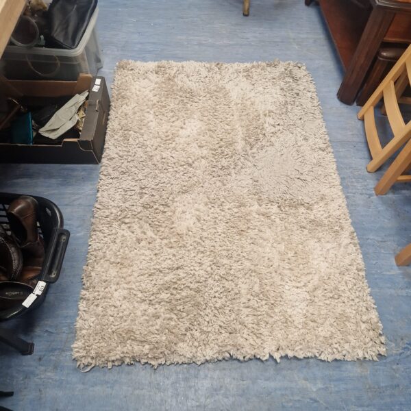 Textured Next woollen rug, approximately 3ft x 5ft, for home decor.
