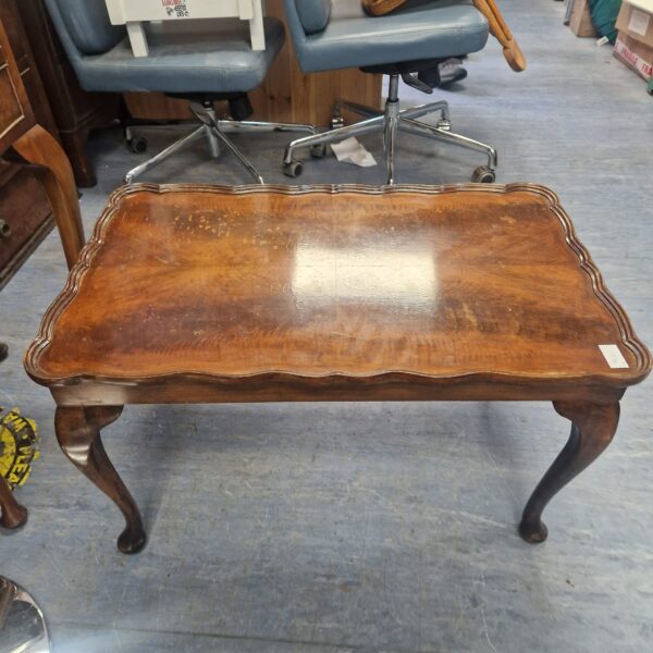 Vintage mahogany coffee table with pie crust edge and curved legs.