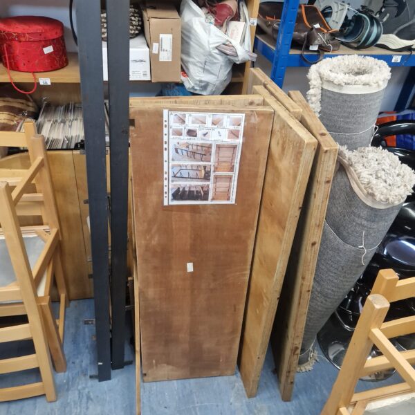 Side view of a used pine shelf unit with visible shelving.