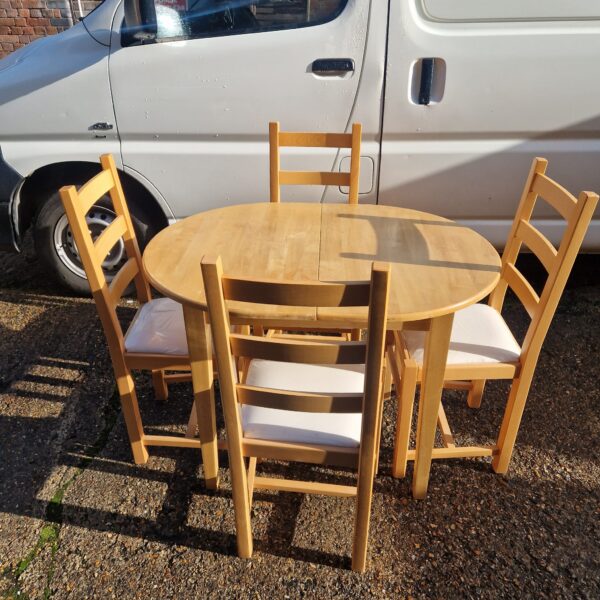 Wooden extending dining set with four chairs in a farmhouse style.