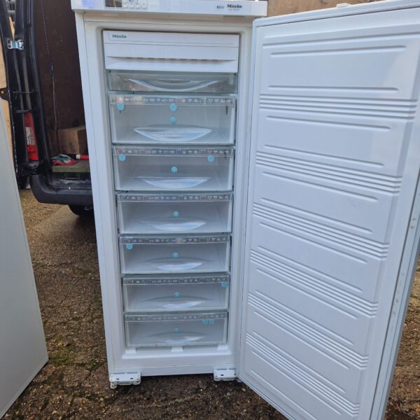 Open view of a white Miele freezer with drawers.
