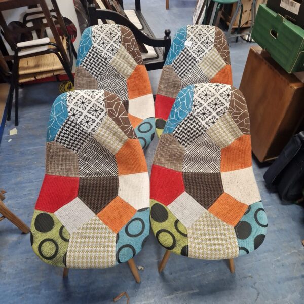 Set of four vibrant patchwork designer chairs with colourful upholstery.