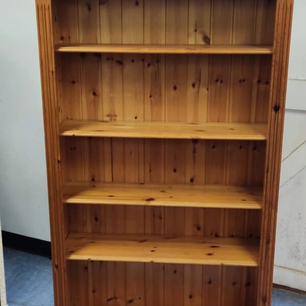 Tall pine bookcase with multiple shelves for books and storage.