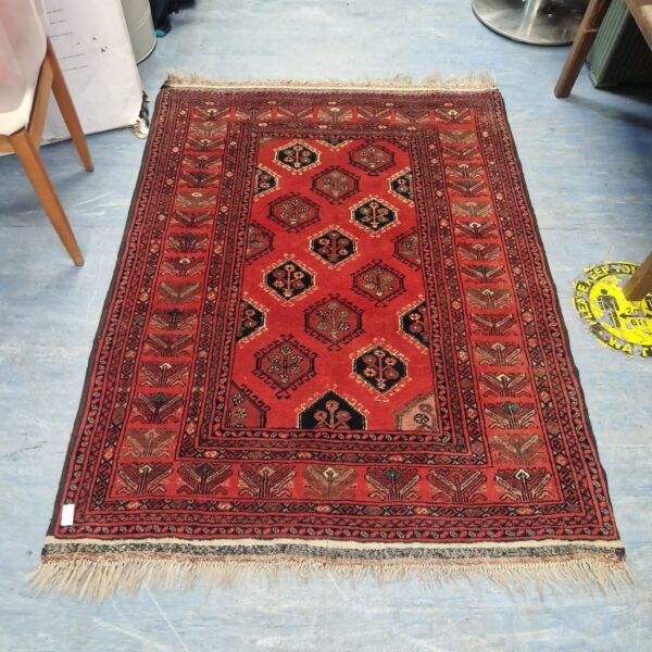 Vibrant red vintage rug with geometric patterns.
