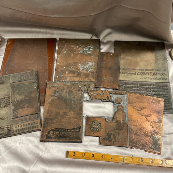 Antique copper printing plates with engraved designs for letterpress printing.