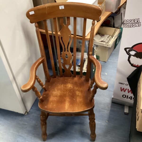 Antique wooden grandfather armchair with high back and spindles.