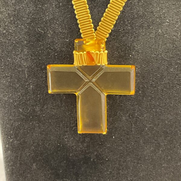 Vintage Baccarat glass cross pendant on display.