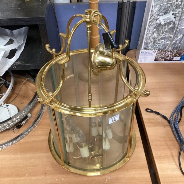 Ornate brass chandelier with glass panels, antique lighting fixture.