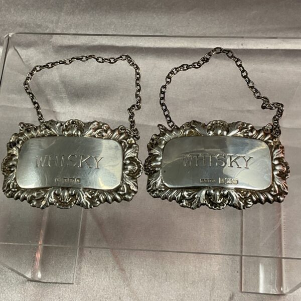 Pair of antique silver whiskey decanter labels with hallmarking.