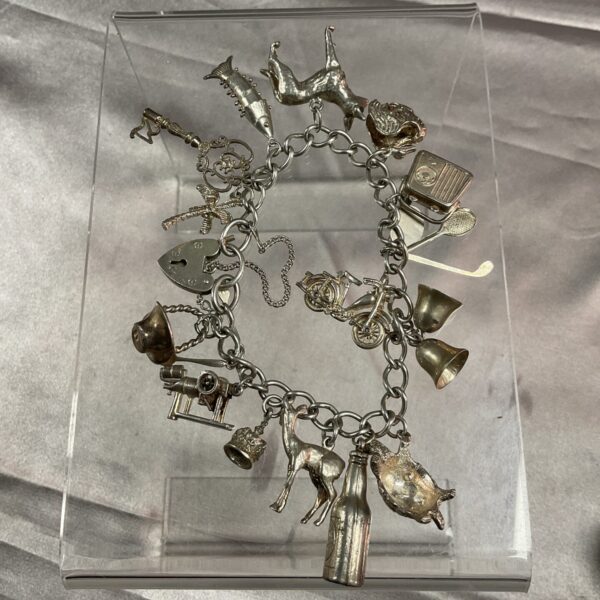 Vintage silver charm bracelet with fifteen detailed charms.