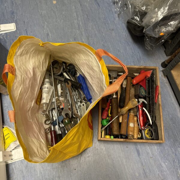 Assorted hand tools in a yellow bag, vintage workshop collection.