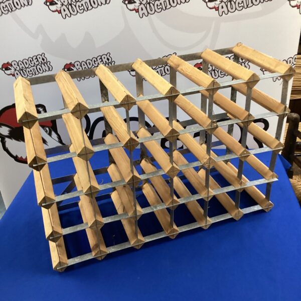 Metal wine rack holding twenty-four bottles for storage.